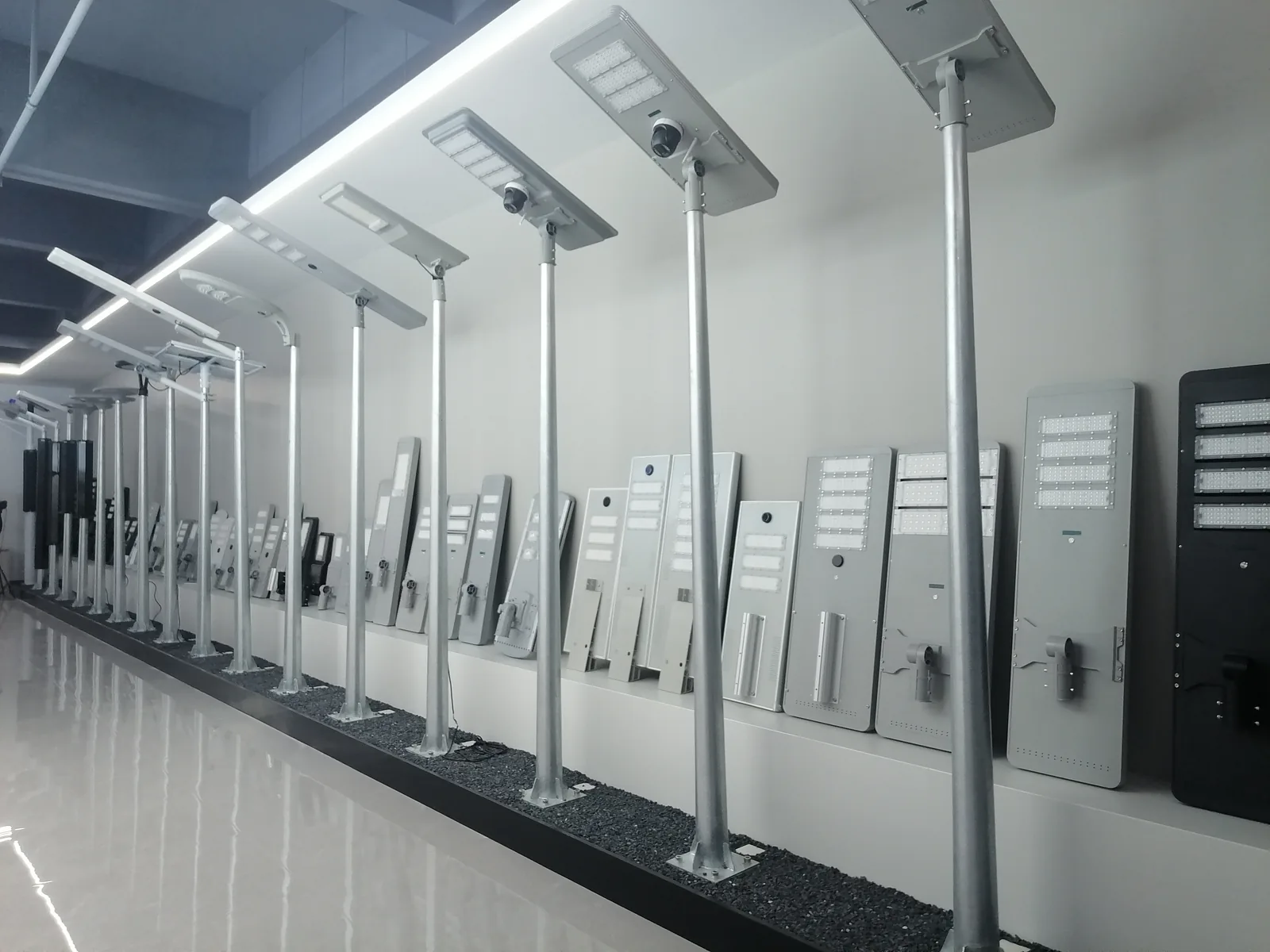 Showroom wall of integrated solar street lights mounted on poles with panel kits on display shelving