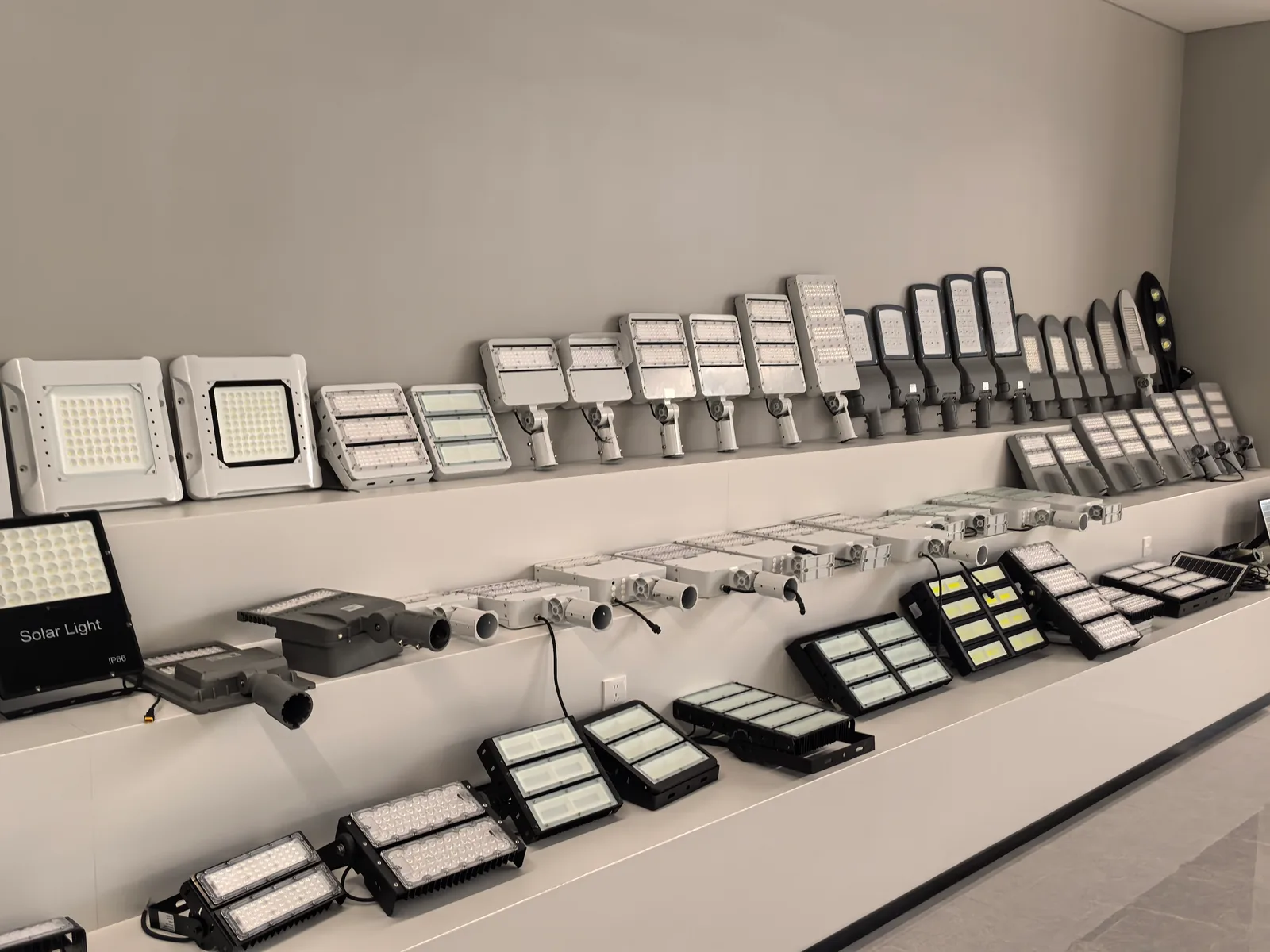 Showroom display of solar flood lights and street-light bodies in profile