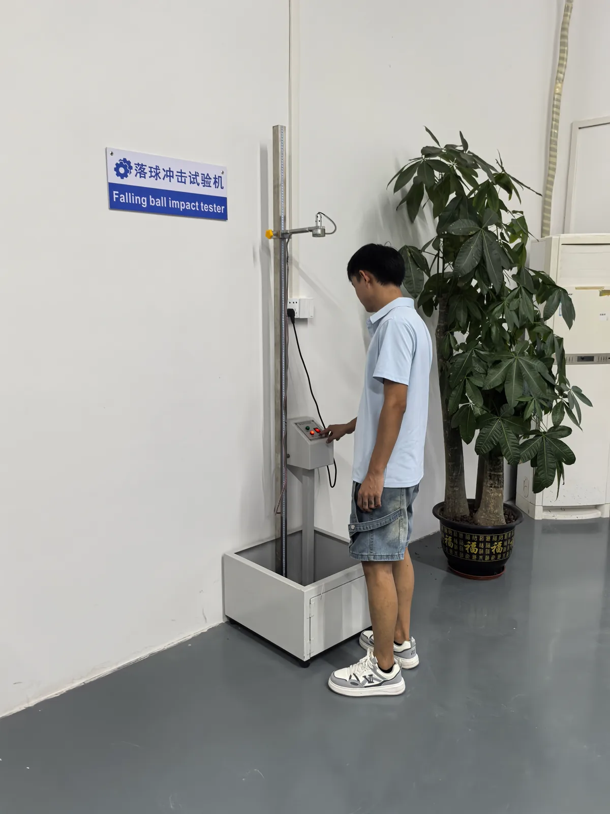 Technician operating the falling ball impact tester