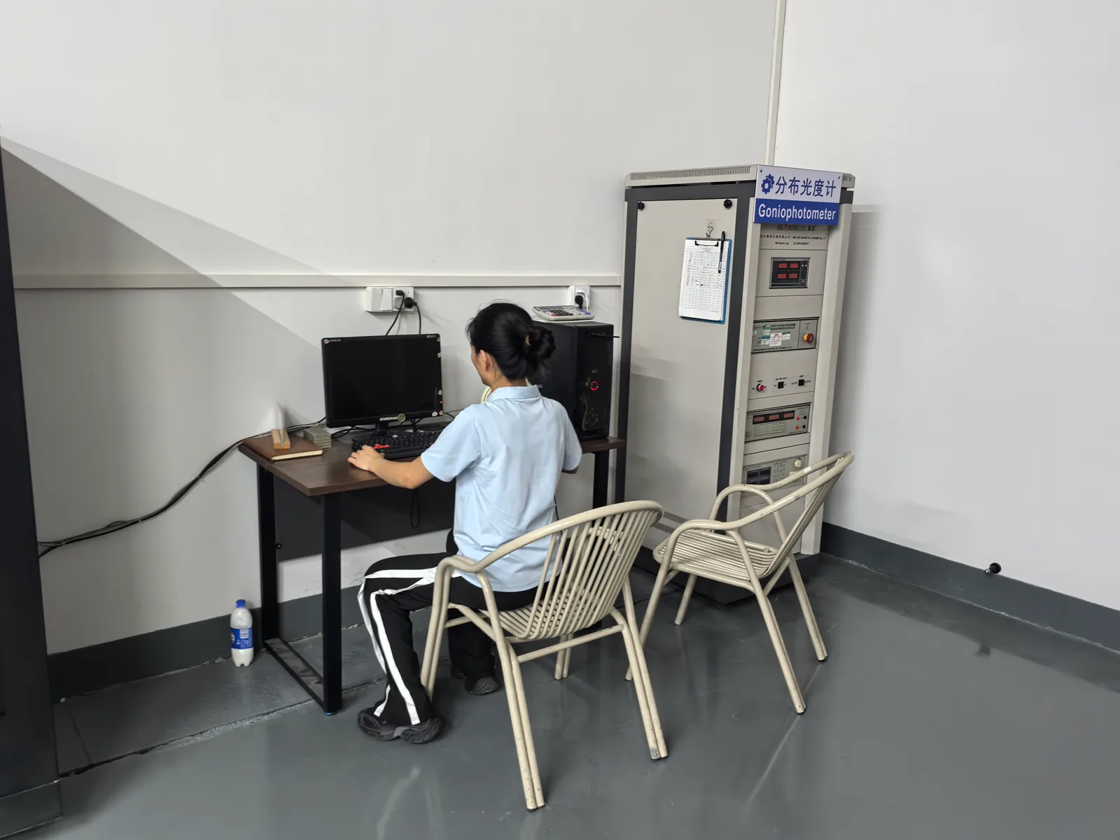 Technician operating the goniophotometer in the photometric dark room