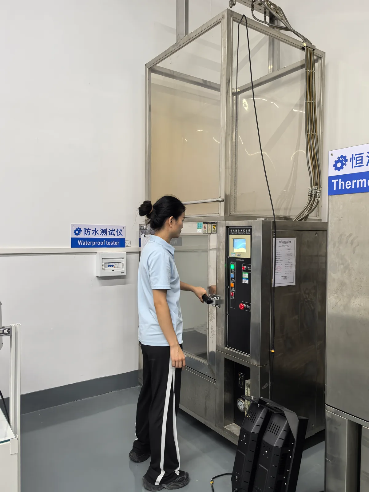 Technician loading a flood light into the waterproof test chamber