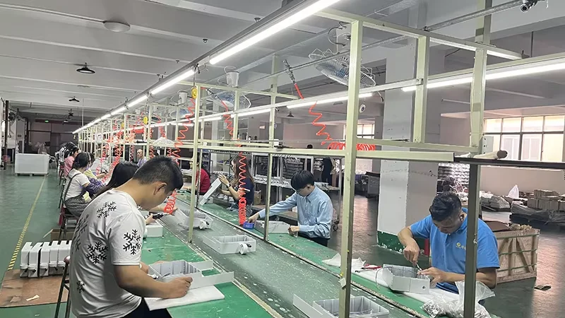 Worker assembling solar street light fixtures on the line